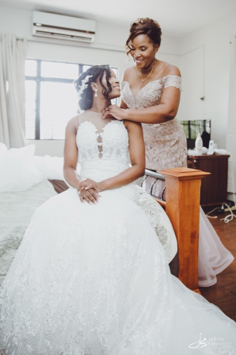 Kinisha in her gown before the ceremony, a bridesmaid at her shoulder