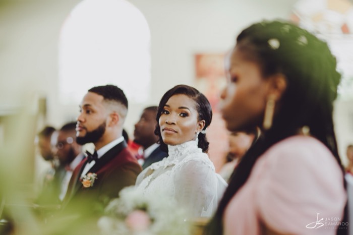Kinisha at the altar during the ceremony, guests seated behind