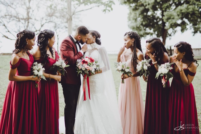 Javon and Kinisha kissing, ringed by their bridesmaids