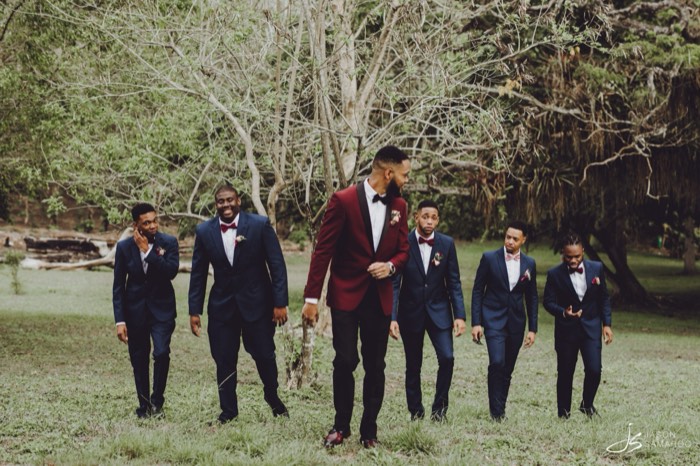 Javon and his groomsmen walking under the trees