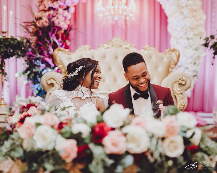 Javon and Kinisha at the head table behind the reception flowers
