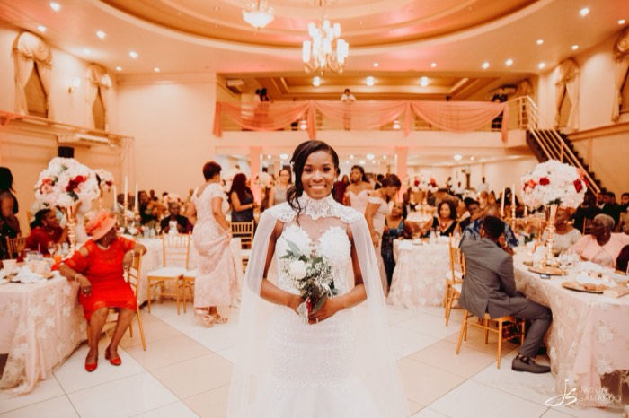 Kinisha crossing the reception hall with her bouquet